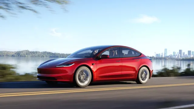 Piros Tesla Model 3 az úton